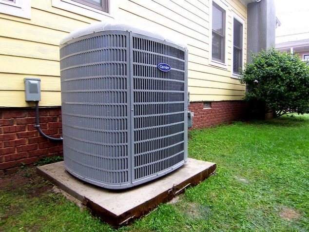 Outdoor air conditioning condenser installed beside a home